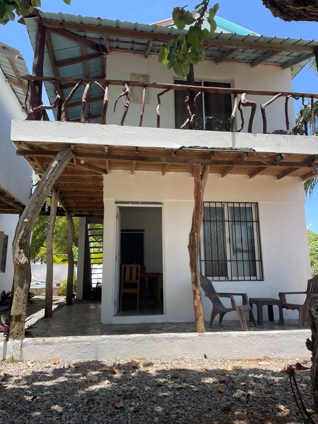 Apartment entrance with a shaded terrace and chairs