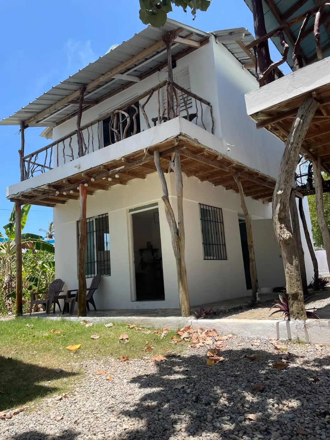 White two-storey apartment with a driftwood balcony and terrace