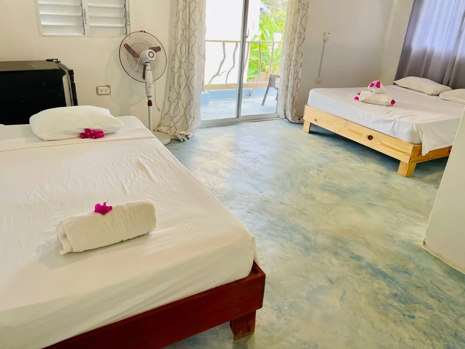 Bright room with two double beds and a door to the balcony