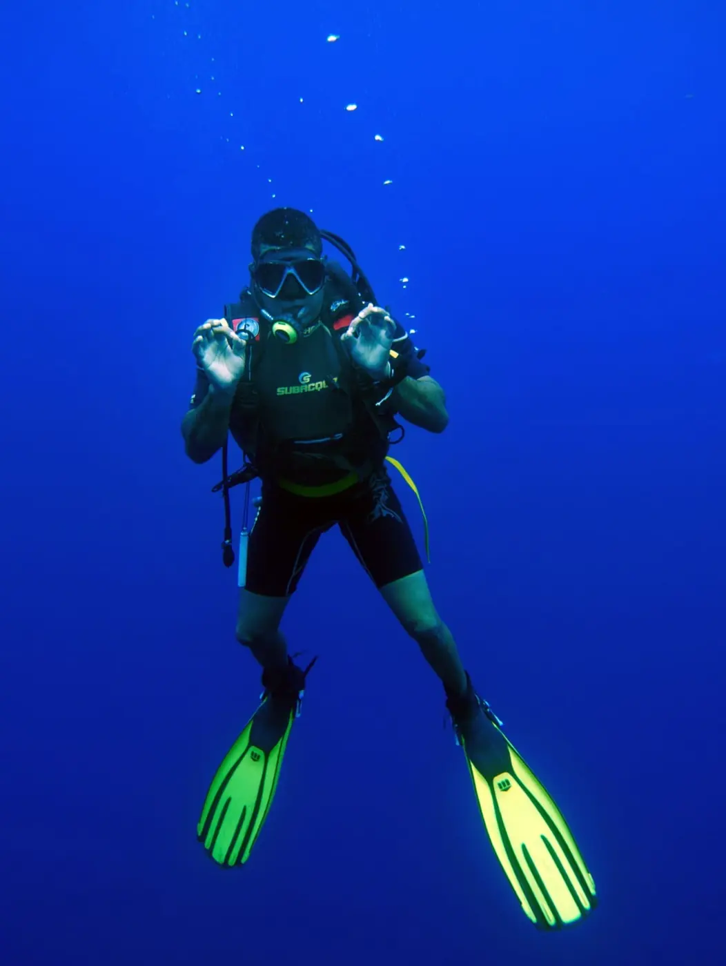 Diver in blue water giving the OK sign